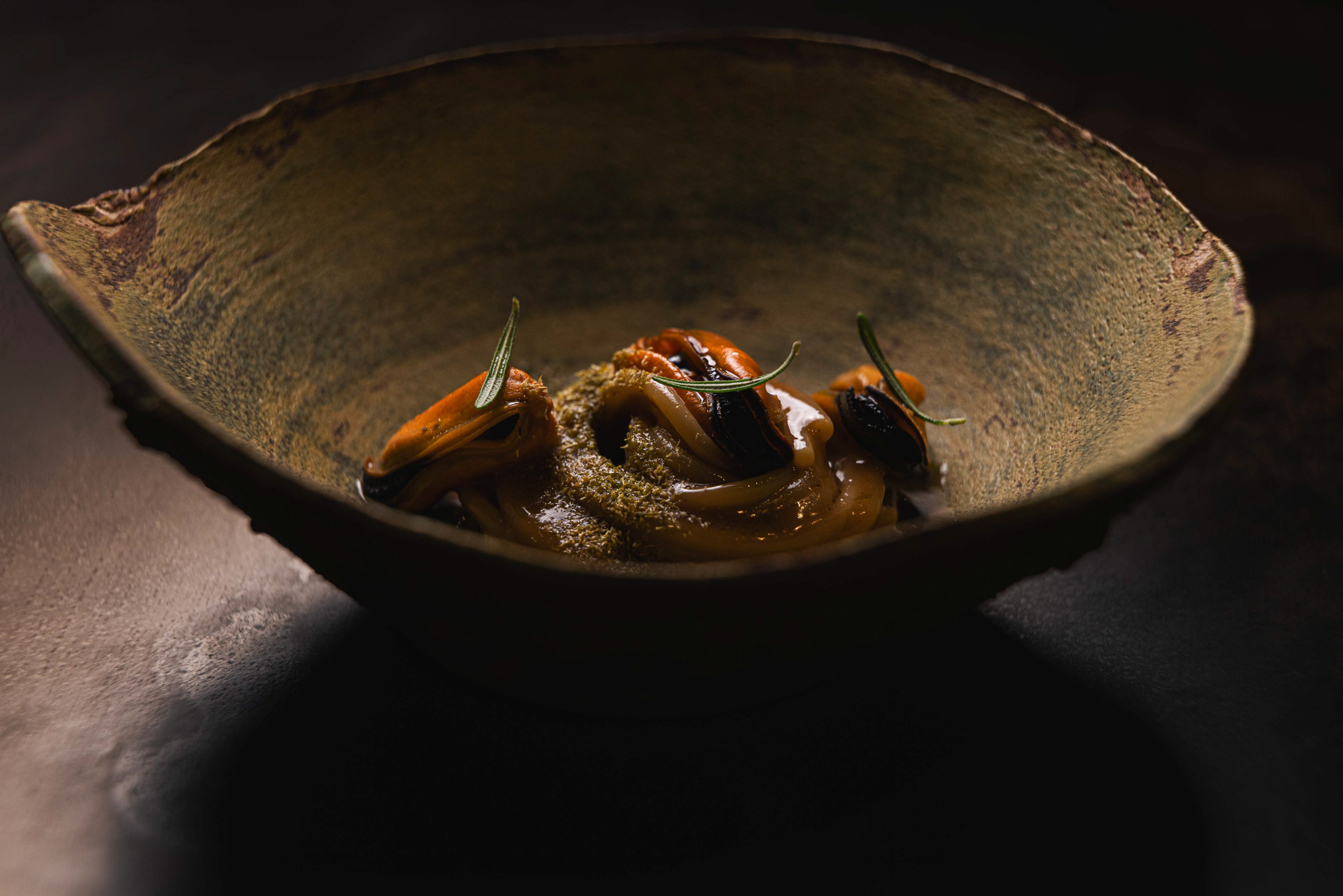 Zuppa di mare servita in ciotola artigianale, luce laterale — Materiaprima, Pontinia