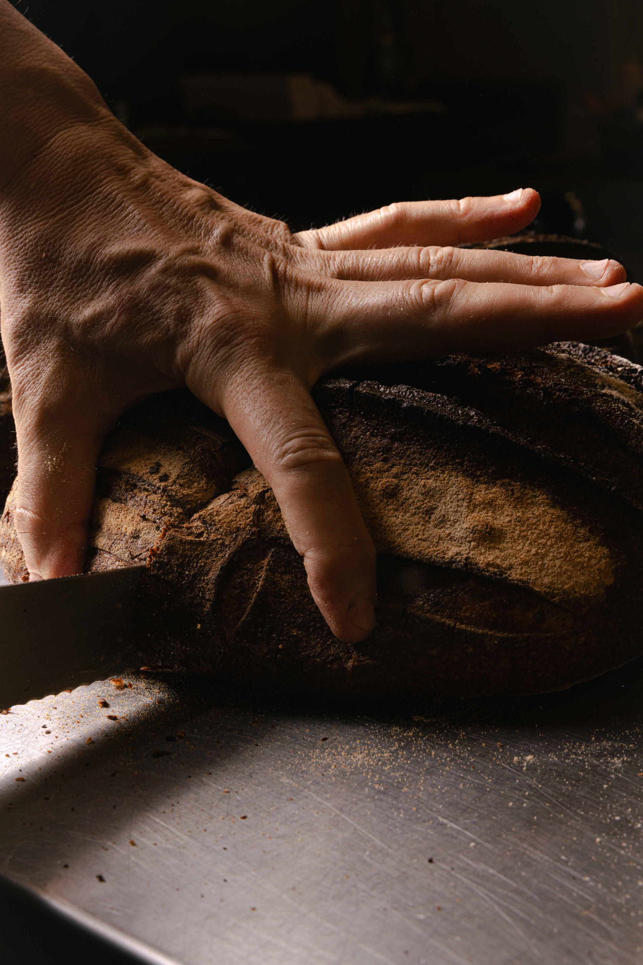 Mani del panettiere sulla pagnotta appena sfornata — Materiaprima, Pontinia