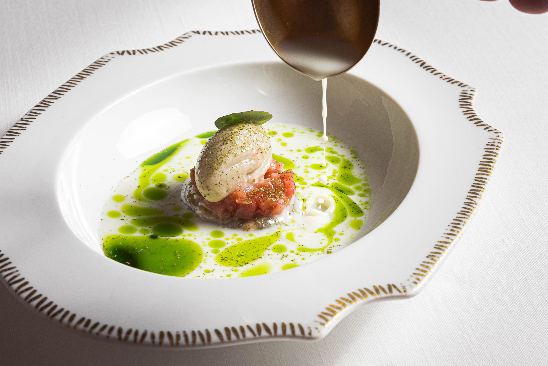Salsa versata al momento su un piatto di pesce, gesto di servizio — Flores Raras, València